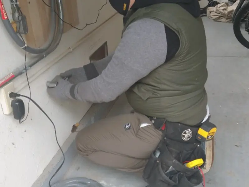 Electrician performing outlet wiring in a St. Albans garage